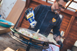 Jorge Gatell, Koch von Papa Corazón Catering bereitet in seinem Garten in Oberursel eine Paella zu. Der Reis wird hinzugefügt.