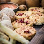 Tortillataler mit rotem Pfeffer bestreut mit anderen leckeren Tapas/Fingerfood auf Holztablett. Darstellung von Tortillas für Rezept Papa Corazón Catering Oberursel