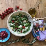 Rucola Salat mit Granatapfel, Mozzarella, Nüssen und Parmesan in feierlicher Schale mit goldenem Salatbesteck, eine Kreation von Papa Corazón Catering aus Oberursel, bei Bad Homburg