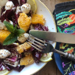 Frischer Orangen Radicchio Salat mit Mozzarella mit Besteck und bunter Serviette als Dekoration für entspannte Gartenparty Büffets