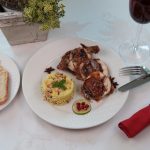 Festliches Gericht: Gefüllte Wachtel mit Cous Cous auf weißem Teller und weißer Tischdecke für Hochzeitscatering