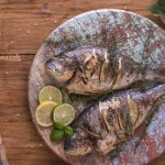 Gegrillte Dorade auf Holzteller Shabby auf Holztisch dekoriert mit Zitrone ein Foto aus Papa Corazón's mediterranem Büffet