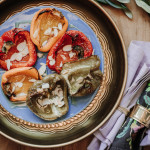 Gegrillte Paprika mit gerösteten Mandeln und Honig auf einem hellblauen Teller für Fest-Büffet